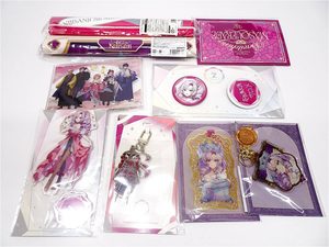 Assorted anime merchandise on a white surface: character art cards, stickers, and a pink-purple keychain set in packaging.