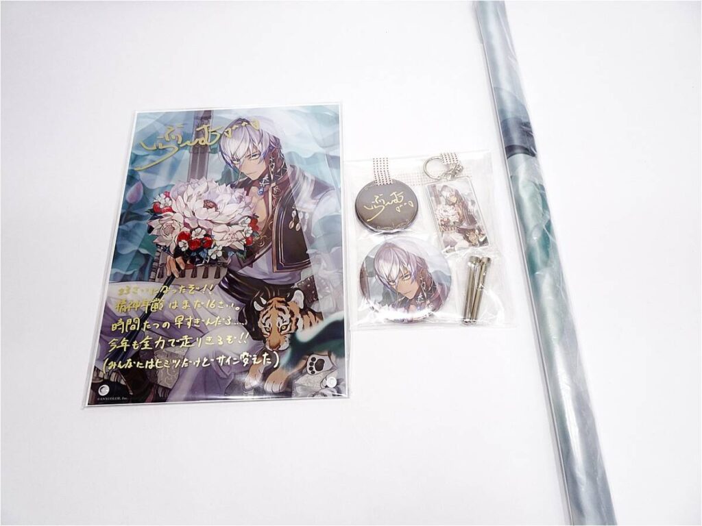 f12069617201 - Vtuberグッズ買取専門店Vtrader Illustrated anime poster showing a silver-haired character holding a flower bouquet with a tiger at the bottom, accompanied by merch in plastic packaging (keychains and charms).