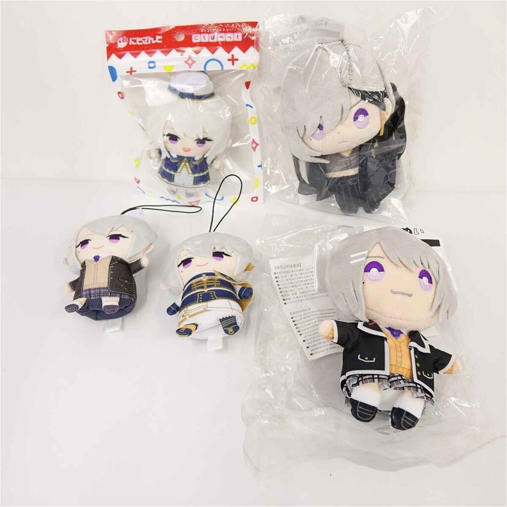 Group of small anime plush dolls with silver hair, wearing uniforms, arranged on a white surface, some in packaging.