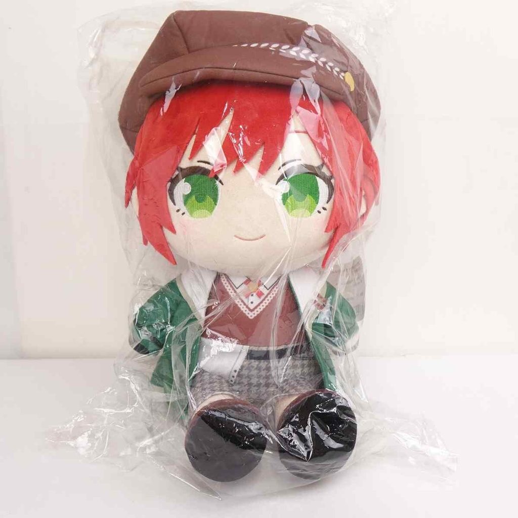 Plush anime-style doll with red hair and green eyes wearing a brown hat and green outfit, wrapped in clear plastic.