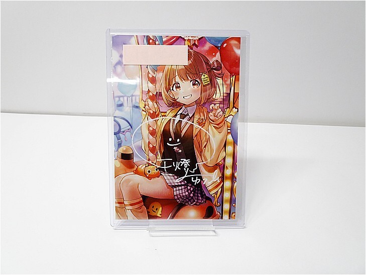i-img729x547-17787408120383qdhlsg33 1 | Vtuberグッズ買取専門店 Anime-style illustration of a girl in a colorful outfit, encased in a clear plastic frame on a white table.