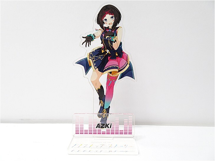 Colorful anime character standee in a dynamic pose on a clear plastic base labeled AZKI.