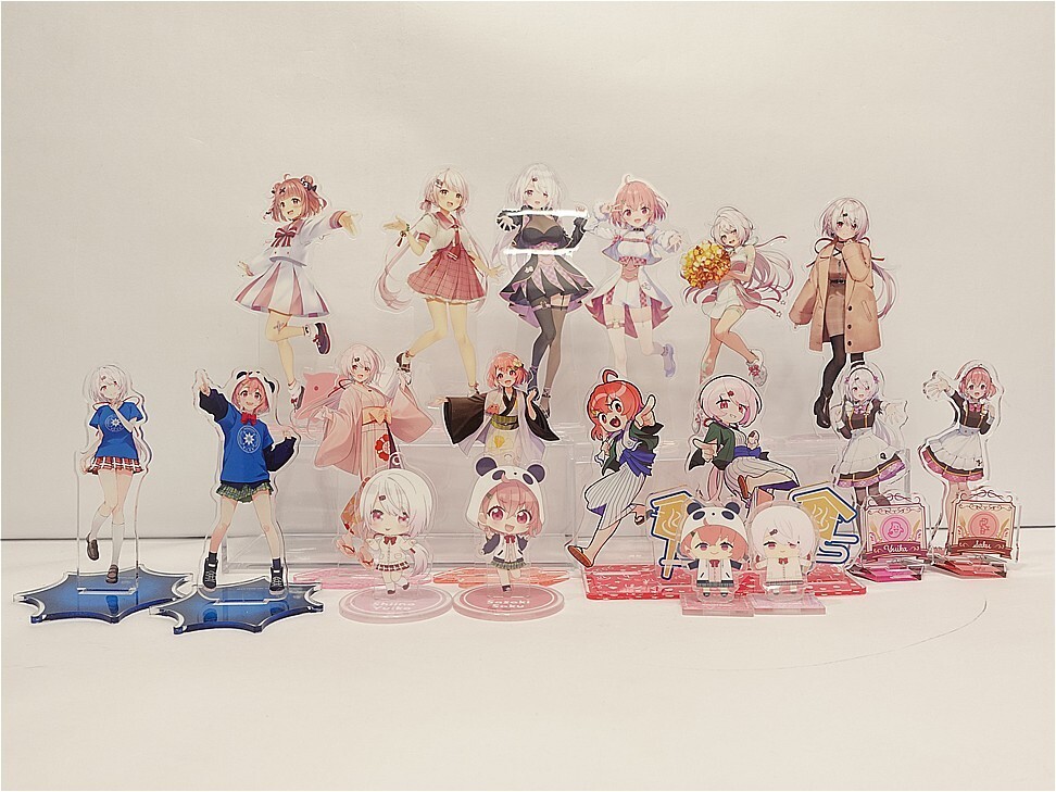 Collection of anime girl acrylic standees in pastel outfits arranged on a white surface.