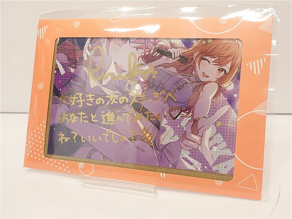 i-img972x729-17725326583866vz9ioh360171 - Vtuberグッズ買取専門店Vtrader Orange-framed package housing an anime-style drawing of a girl singing into a microphone, reaching toward the viewer.