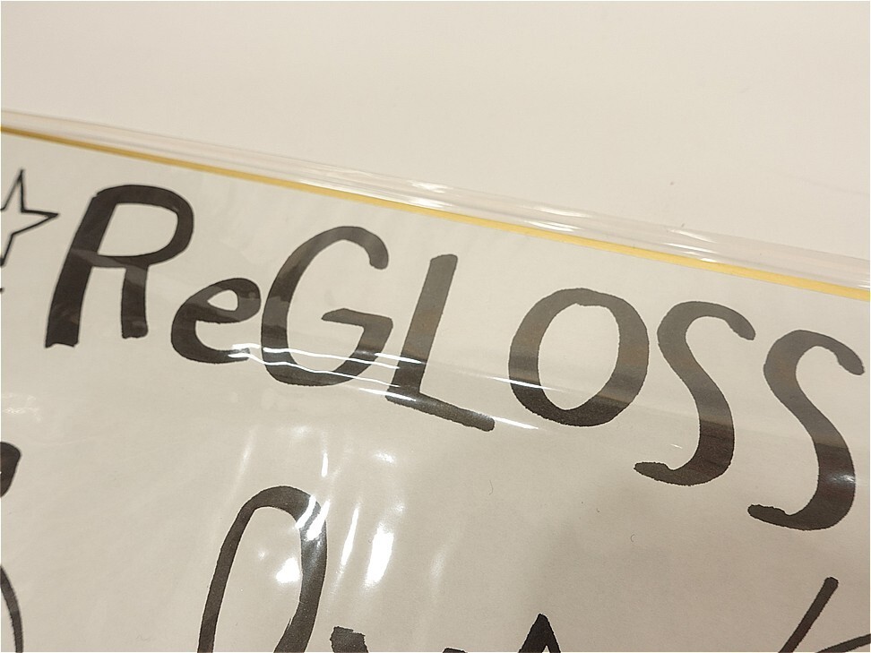 Close-up of a sign with the word 'RegLoss' in bold black letters on a white background, rotated slightly.