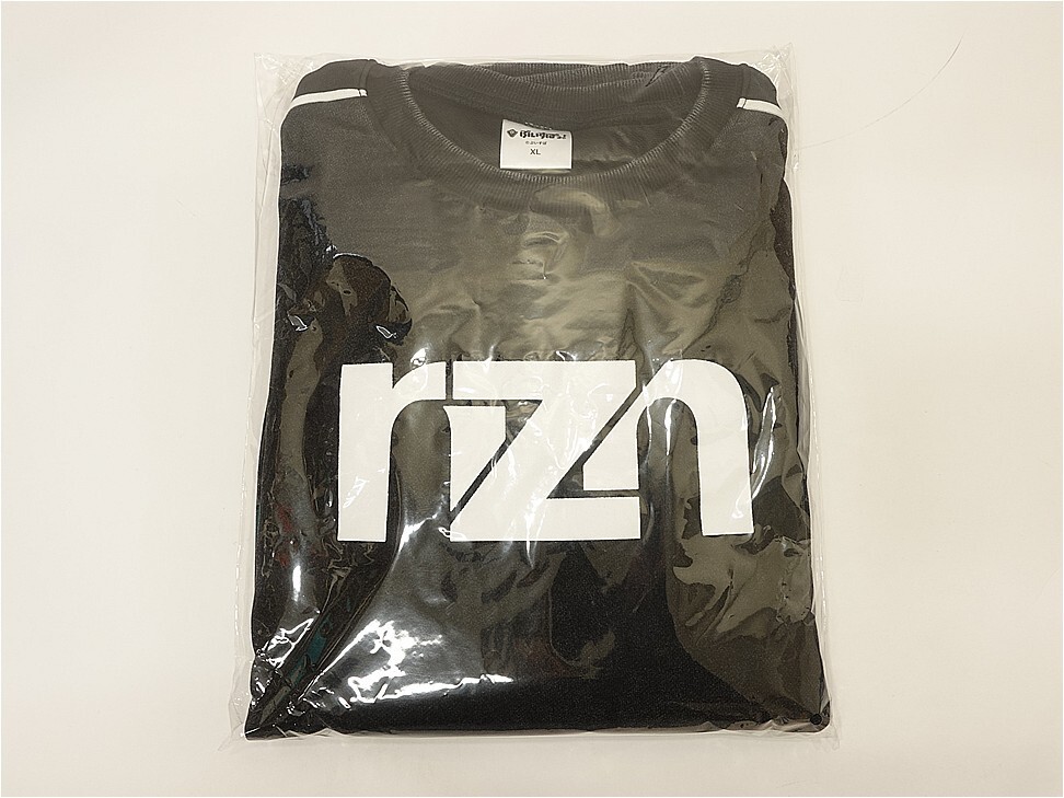 Black folded T-shirt sealed in clear plastic packaging with a large white stylized logo across the front.