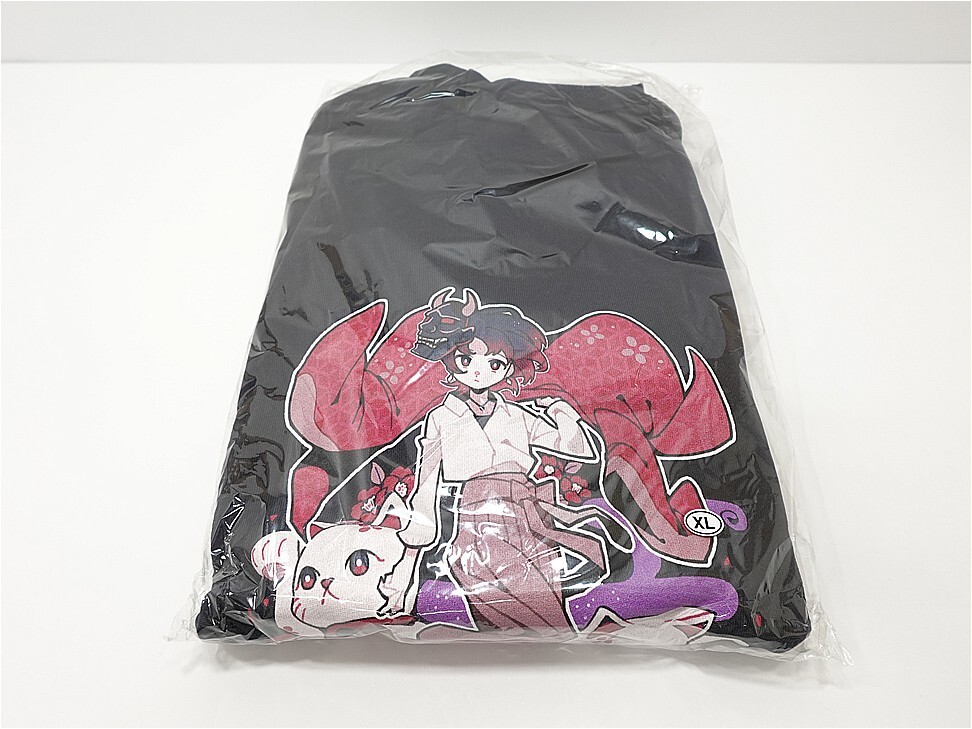 Black hoodie in clear plastic packaging with a pink anime girl and a white cat illustration; size XL badge visible.
