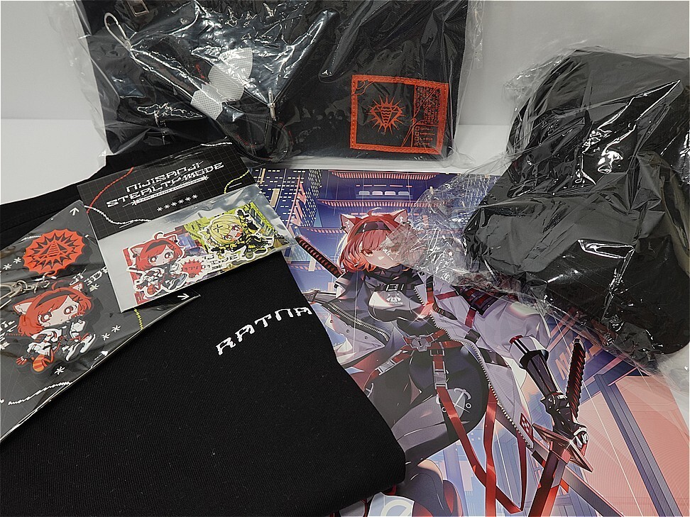 Assorted anime merchandise: black hoodies in plastic, character cards, and a poster with a red-haired swordswoman on a blue background.