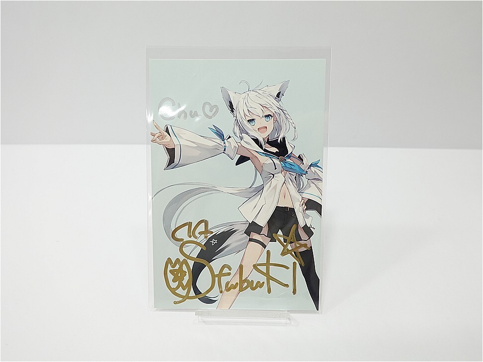 Autographed anime illustration card showing a white-haired, cat-eared girl in a white jacket, posing with outstretched arm.