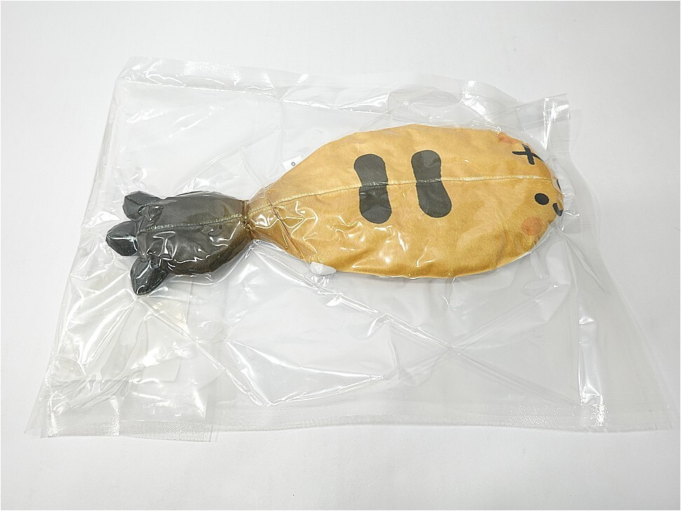 Cartoon fish plush toy with a yellow body and gray tail inside a clear plastic bag.