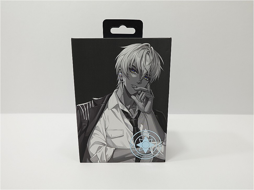 Front of a black packaging box featuring a grayscale anime character in a white shirt and tie, smoking, with a blue compass emblem at the bottom right.