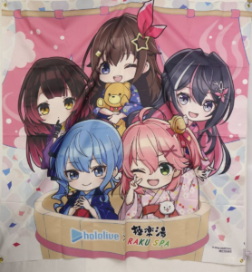 image | Vtuberグッズ買取専門店 Six chibi anime girls in yukatas pose together on a pink banner, smiling with a teddy bear; Hololive and RAKU SPA logos visible at the bottom.