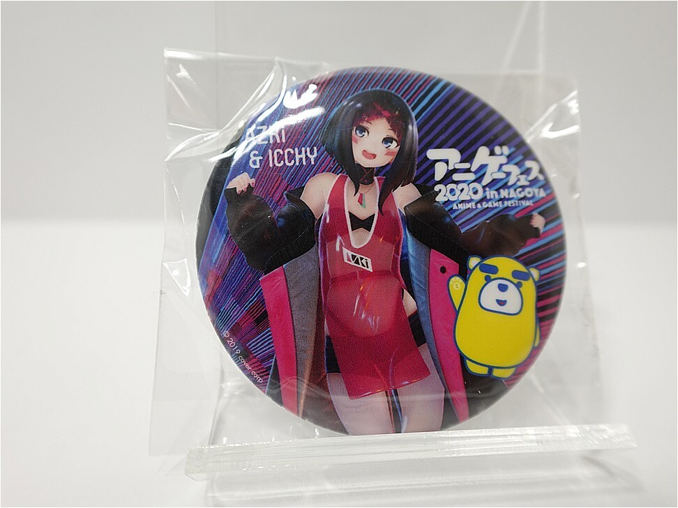 Round anime badge showing a female character in a red dress with black gloves and a yellow bear mascot, sealed in plastic packag​ing.