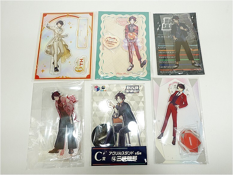 Six packaged anime character standees laid out on a white surface, showing the same male character in different outfits and poses.