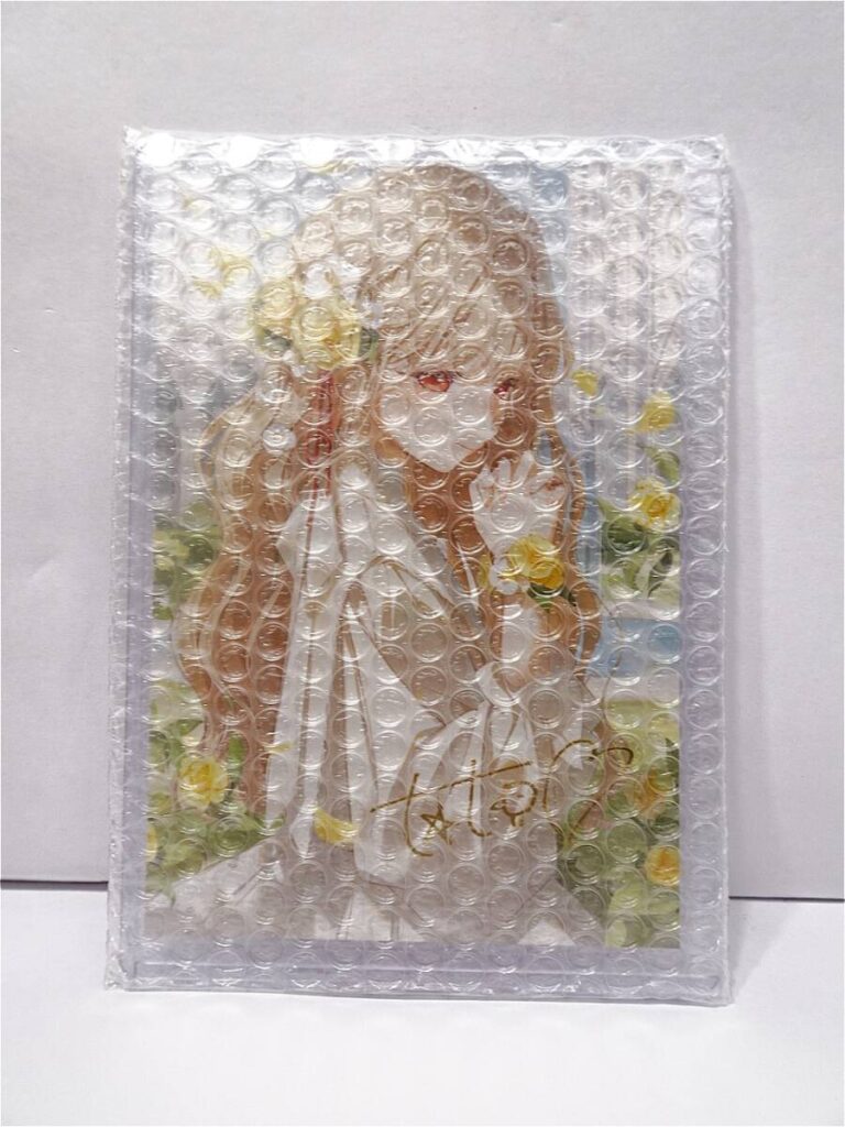 r12047495311 - Vtuberグッズ買取専門店Vtrader Illustration of a bride in a white wedding dress with flowers, wrapped in bubble wrap on the packaging.