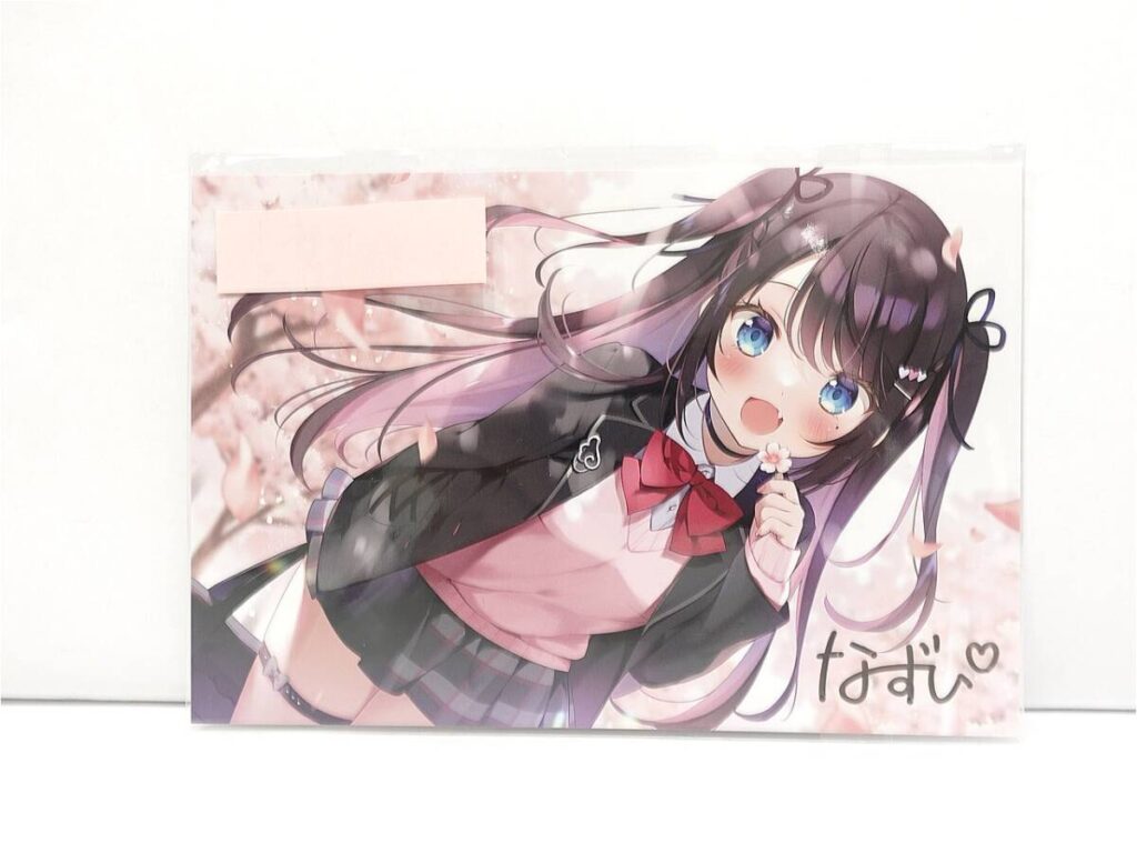 Cheerful anime girl with long dark hair and blue eyes in a pink cardigan and black jacket, holding a flower with a cherry blossom background.