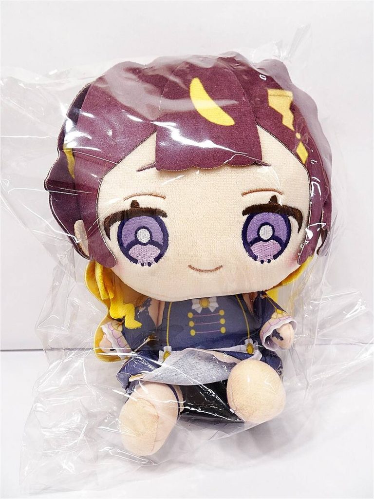 x12083027671 1 | Vtuberグッズ買取専門店 Soft plush doll of an anime-style girl with purple hair and large purple eyes, wearing a blue outfit, inside a clear plastic bag.